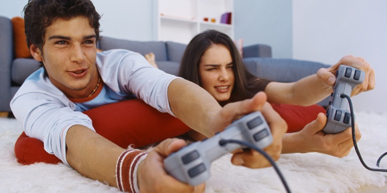 Close-up of a young couple lying on the floor and playing a video game