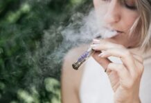 Une femme fume une cigarette électronique