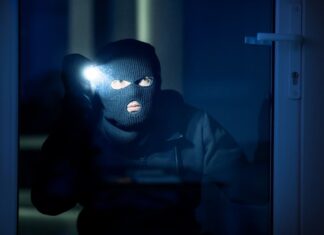 Se prémunir du phénomène du home jacking grâce à une alarme de qualité cambrioleur dans une maison avec une lampe